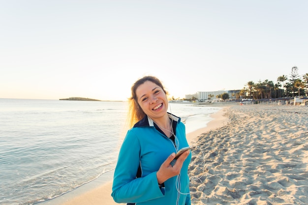 Sport en lifestyle concept - vrouw na het hardlopen met koptelefoon buitenshuis.