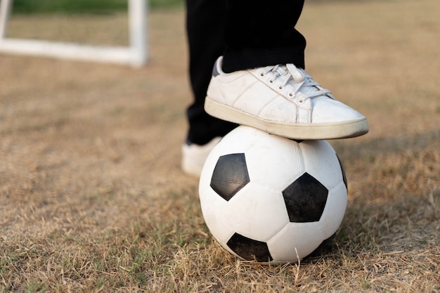 Sport en recreatie een bal gestopt door een voet met een witte sneaker op het voetbalveld.