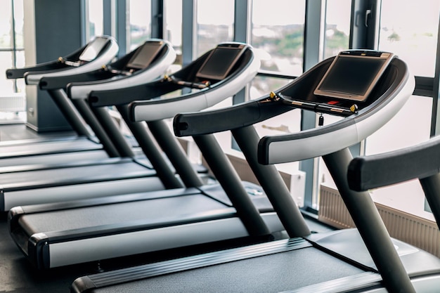 Sport Equipment Modern Treadmills With Control Panels Standing In Row At Gym