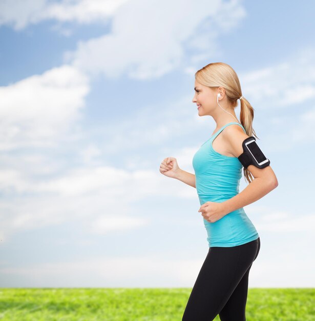 sport, excercise, technology, internet and healthcare - sporty woman running and listening to music from smartphone