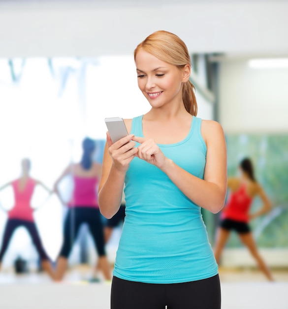 sport, excercise, technology, internet and healthcare - sporty woman with smartphone