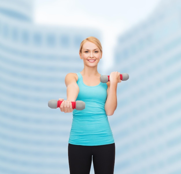 концепция спорта, упражнений и здравоохранения - молодая спортивная женщина с легкими гантелями