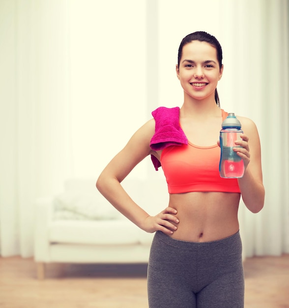 sport, exercise and healthcare - sporty woman with pink towel and water bottle