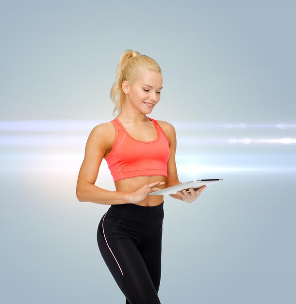 sport, exercise, technology, internet and healthcare concept - smiling sporty woman with tablet pc computer