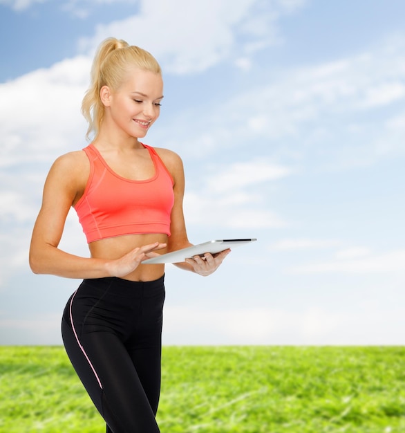 спорт, упражнения, технологии, интернет и концепция здравоохранения - улыбающаяся спортивная женщина с планшетным компьютером