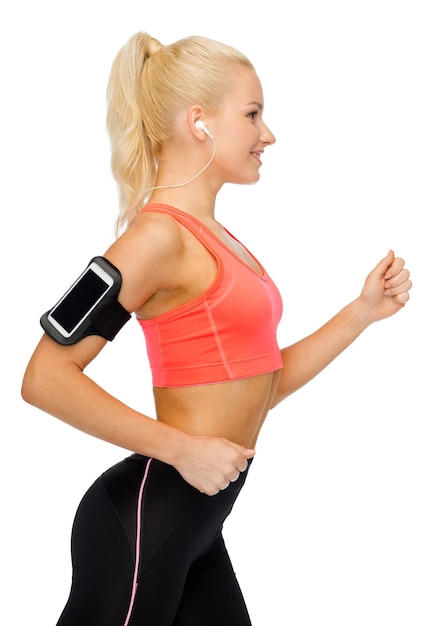 sport, exercise, technology, internet and healthcare - smiling sporty woman running and listening to music from smartphone