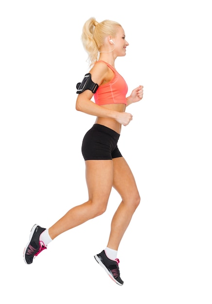 sport, exercise, technology, internet and healthcare - smiling sporty woman running and listening to music from smartphone