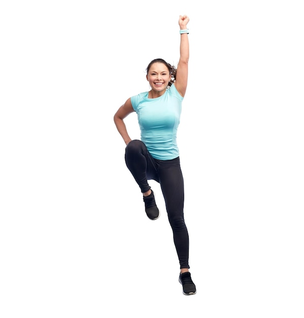 sport, fitness, beweging en mensen concept - gelukkige glimlachende jonge vrouw springt in superheld pose over witte achtergrond