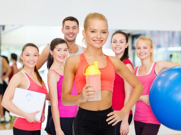концепция спорта, фитнеса и диеты - улыбающаяся спортивная женщина с бутылкой протеинового коктейля