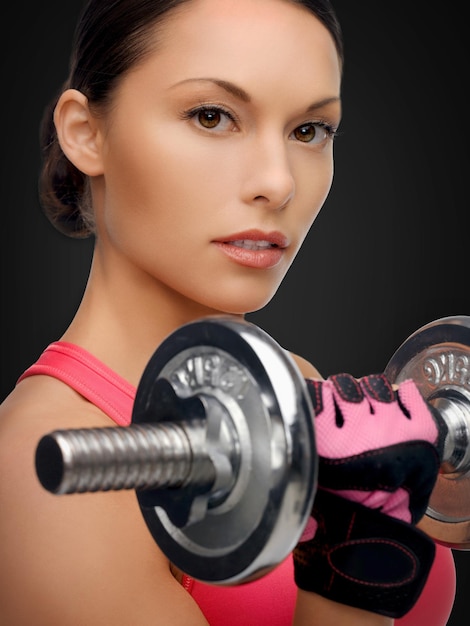 sport, fitness en gezondheidszorg concept - mooie aziatische sportieve vrouw met zware dumbbell