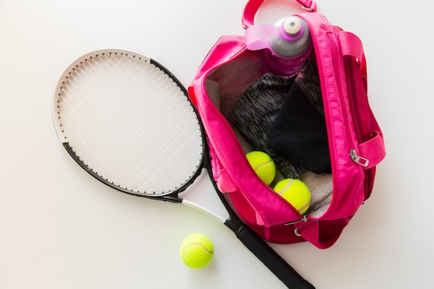 sport, fitness, gezonde levensstijl en objecten concept - close-up van tennisracket en ballen met vrouwelijke sporttas