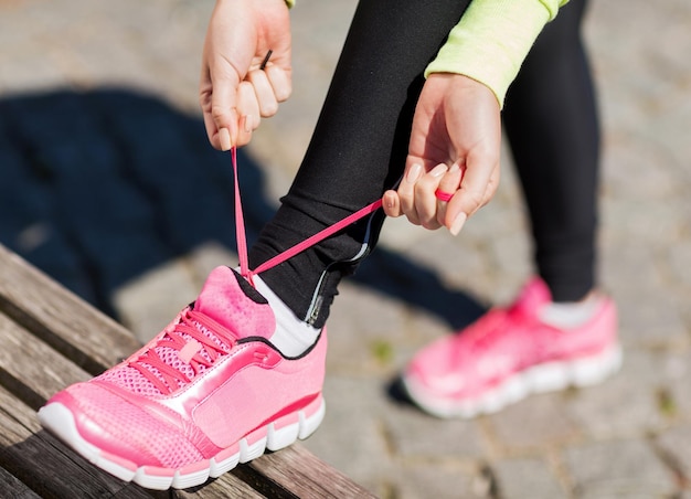 sport, fitness, lichaamsbeweging en lifestyle concept - runner vrouw veterschoenen trainers