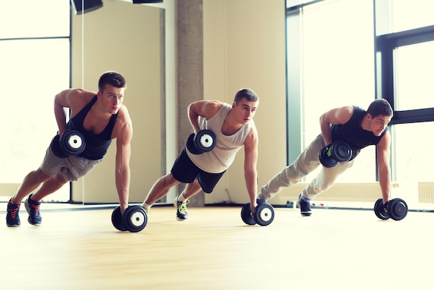 sport, fitness, lifestyle en mensen concept - groep mannen met halters in de sportschool