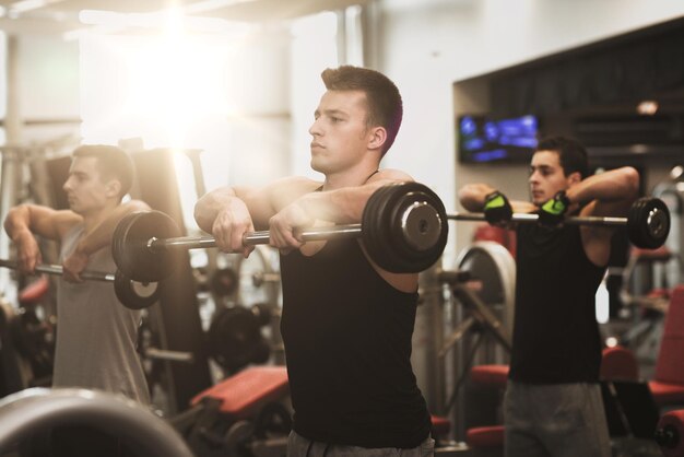 sport, fitness, lifestyle and people concept - group of men with barbells in gym