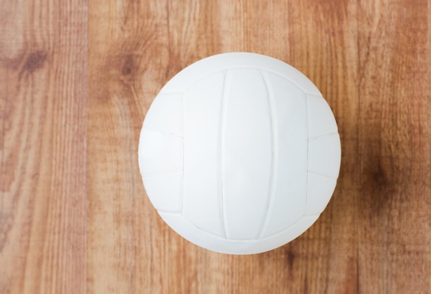 sport, fitness, spel, sportartikelen en objecten concept - close-up van volleybalbal op houten vloer van bovenaf