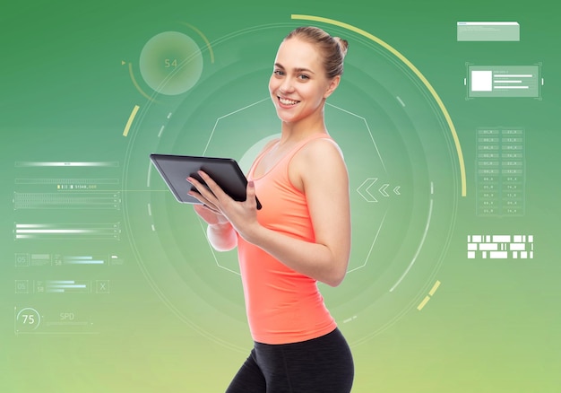 sport, fitness, technologie en mensenconcept - gelukkige glimlachende sportieve jonge vrouw met de computer van tabletpc