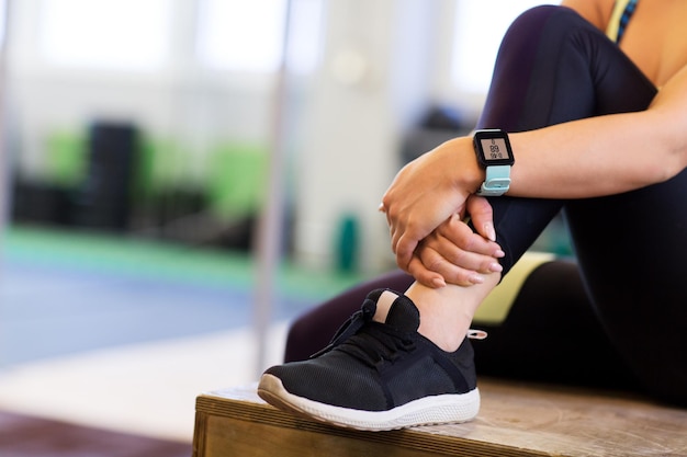 sport, fitness, technology, lifestyle and people concept - close up of woman with heart rate tracker in gym