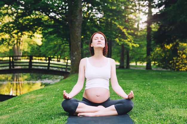 Sport fitness while pregnancy Pregnant woman practicing yoga breathing exercise stretching