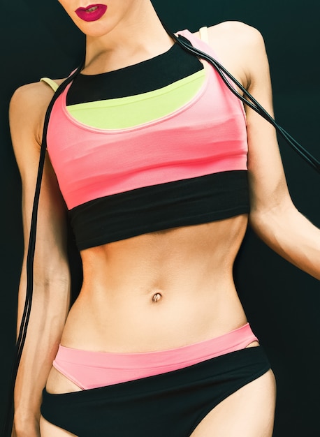 Sport fitness woman on a black background in bright sportswear