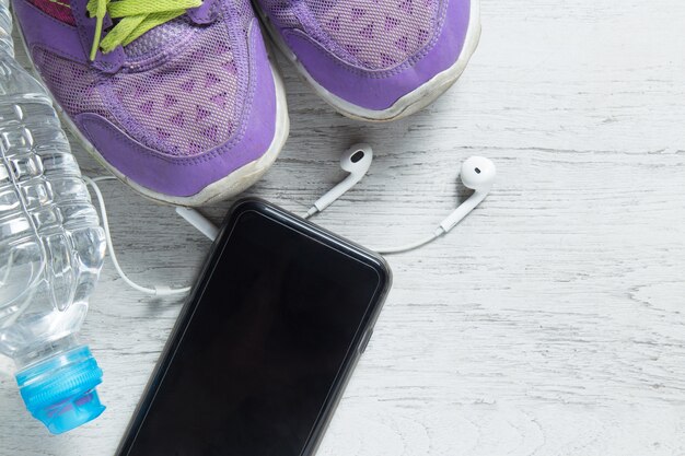 Sport flat lay purple shoes, smartphone and workout equipments 