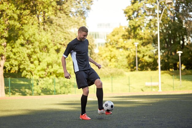 Foto sport, calcio e persone - calciatore che gioca e gioca con la palla sul campo