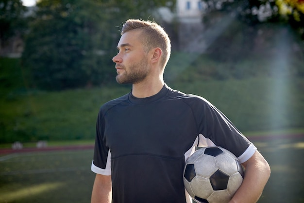 sport, football training and people - soccer player with ball on field