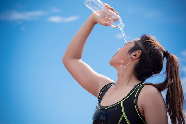 Sport girl pouring water on her face when rest or take a break time, Relax and Sport concept