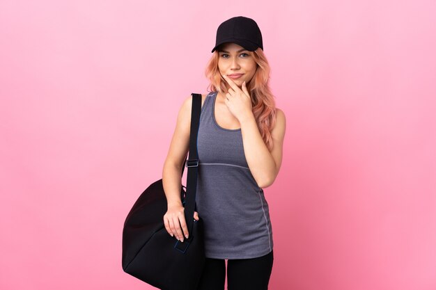 sport girl teenager with sport bag over isolated thinking