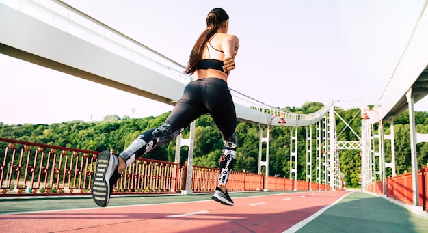 Sport and health lifestyle. back view shot of running young\
woman in sport clothes outdoors