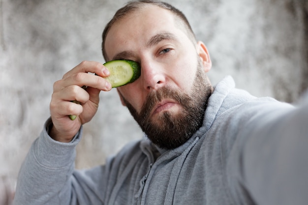 Photo sport, health, people, emotions lifestyle concept - handsome man with three different face masks chocolate, cream and clay masks. photo of man with perfect skin. grooming himself