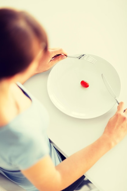 sport, healthcare and diet concept - woman with plate and one tomato
