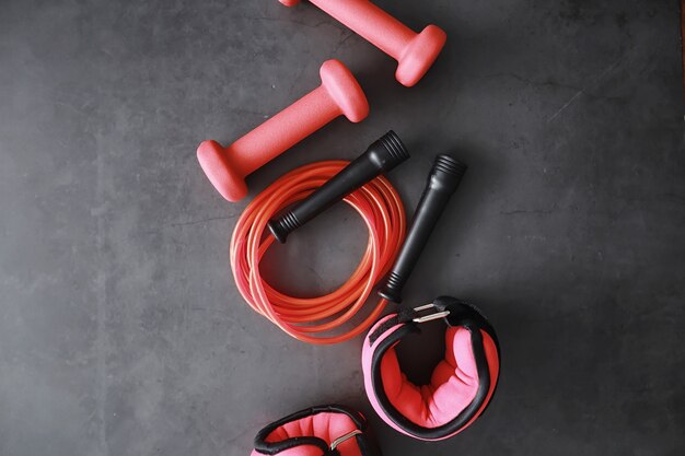 Sport and healthy lifestyle. Accessories for sports. Yoga mat dumbbell and jump rope. Sports background with home exercises concept.