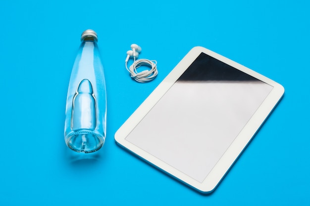 sport, healthy lifestyle and objects concept - close up of tablet pc computer with water bottle