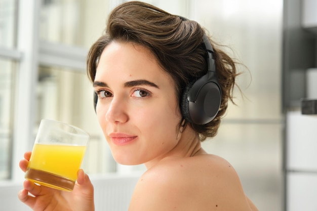 Sport and healthy lifestyle portrait of happy sporty girl fitness woman in headphones rewinds at hom