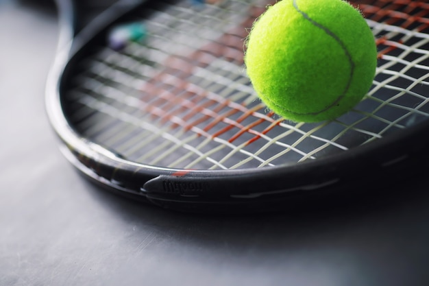 Sport and healthy lifestyle. Tennis. Yellow ball for tennis and a racket on the table. Sports background with tennis concept.