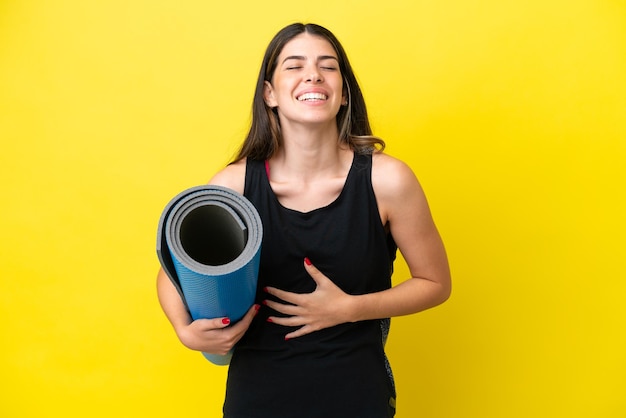 Sport Italiaanse vrouw die naar yogalessen gaat geïsoleerd op een gele achtergrond die veel lacht