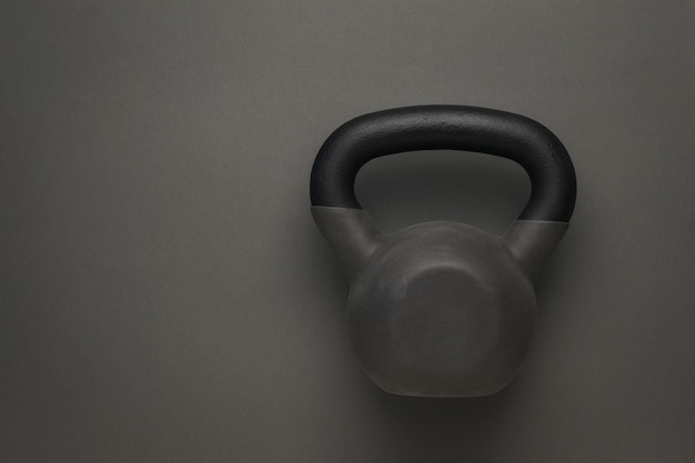 Sport kettlebell bedekt met rubber op een donkergrijze ondergrond. sportieve levensstijl.