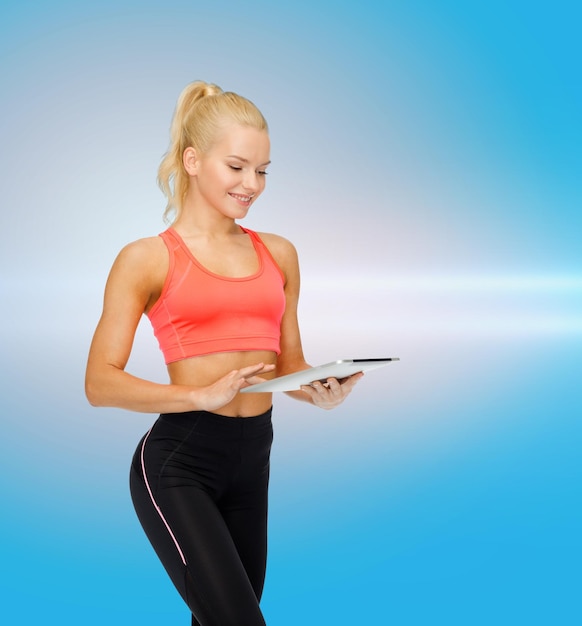 sport, lichaamsbeweging, technologie, internet en gezondheidszorg concept - lachende sportieve vrouw met tablet pc-computer