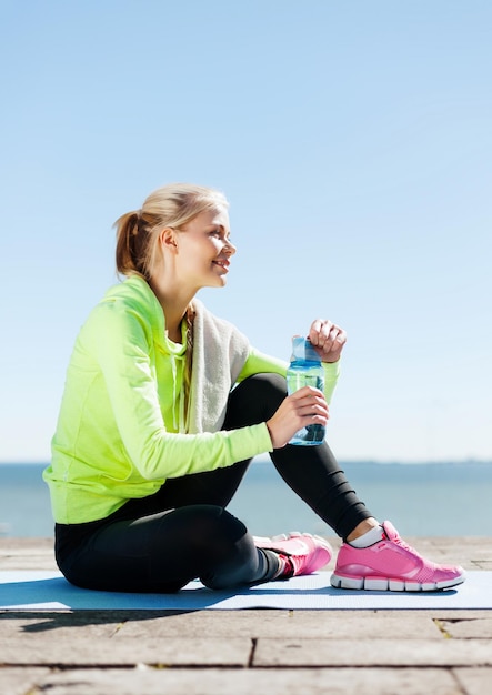 sport and lifestyle concept - woman resting after doing sports outdoors