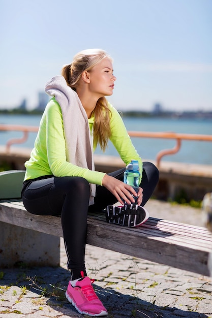 sport and lifestyle concept - woman resting after doing sports outdoors