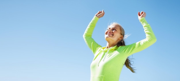 Photo sport and lifestyle concept - woman runner celebrating victory