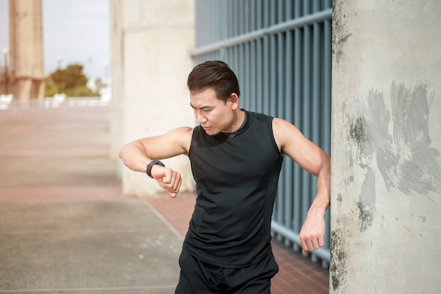 Sport man checking time at outdoor city