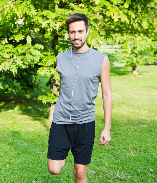 Foto sport man die zich uitstrekt in het park