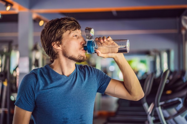 Sport man drinkwater in de sportschool