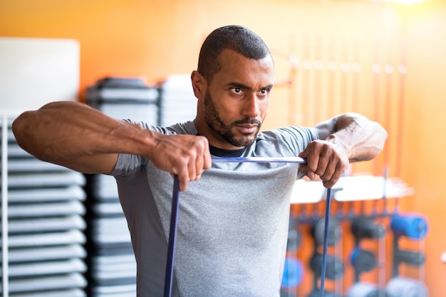 Photo sport man in the gym with elastic band