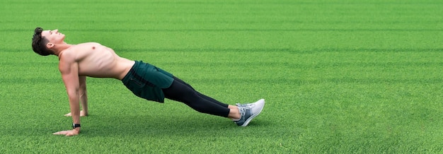 Sport man op groen gras kopieer ruimte sport omgekeerde plank oefening buiten omgekeerde plank