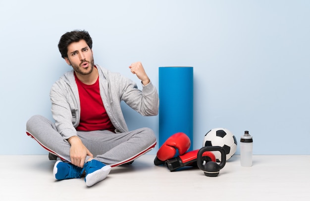 Sport man sitting on the floor doing strong gesture