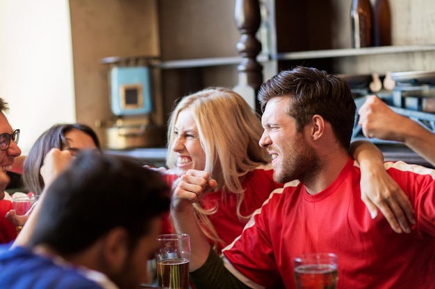 sport, mensen, vrije tijd, vriendschap en entertainment concept - gelukkige voetbalfans of vrienden die bier drinken en de overwinning vieren in de bar of pub