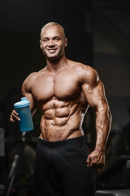 Sport muscular fitness man drinking water after workout cross fitness and bodybuilding concept gym   abs muscle exercises in gym naked torso fitness concept