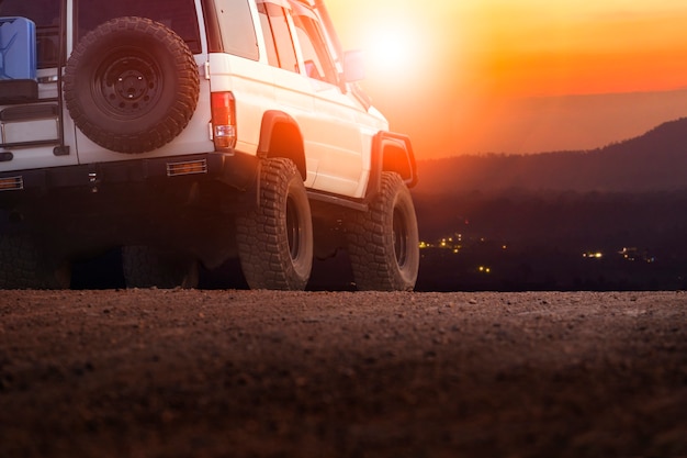 sport offroad vehicle on dirt field against sun set sky for traveling and outdoor lifestyle